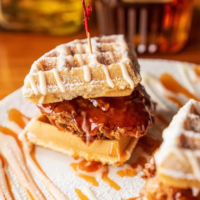 Crispy fried chicken and waffles, glazed and dusted with powdered sugar.