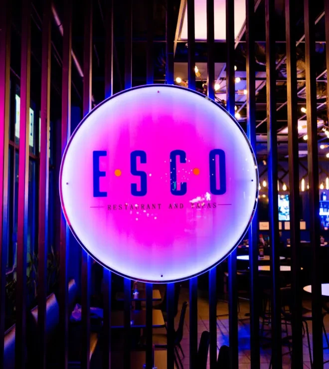 Circular pink and blue neon 'ESCO RESTAURANT AND TAPAS' sign.