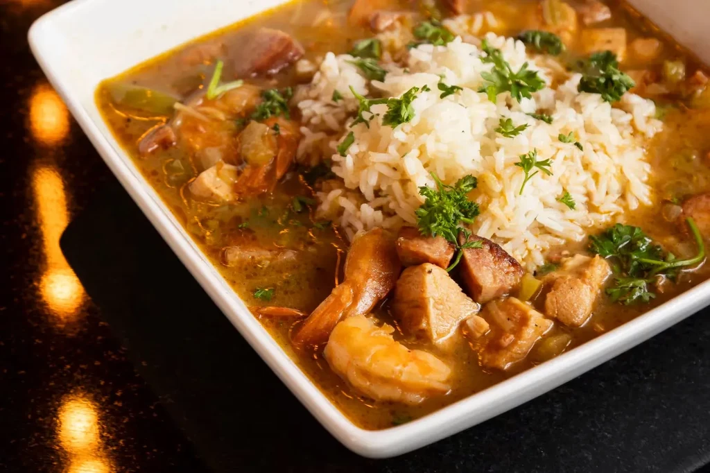 Bowl of gumbo with rice, shrimp, chicken, and sausage.