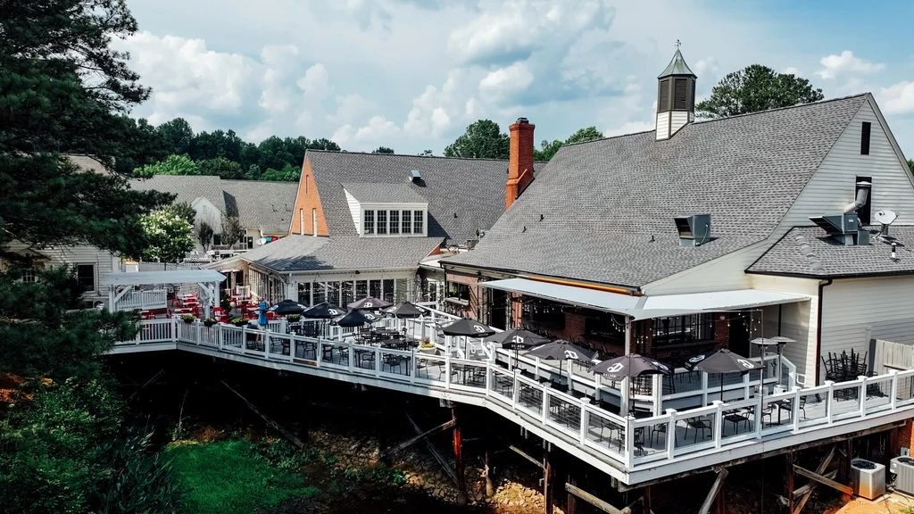 Aerial view of multi-level restaurant with large deck above ravine.