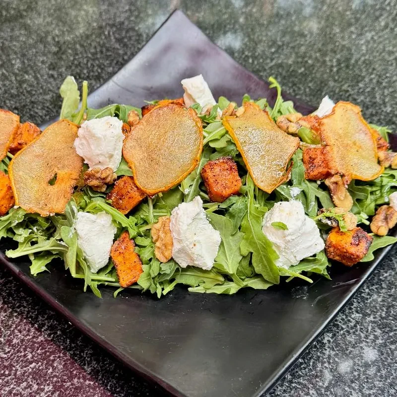 Arugula salad with roasted pear, sweet potato, goat cheese, and walnuts.