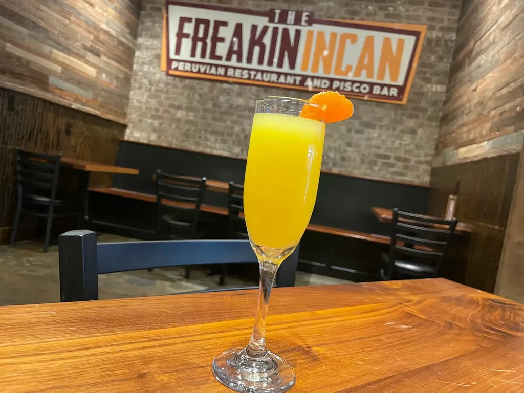 Yellow-orange drink with orange peel at The Freakin Incan restaurant.