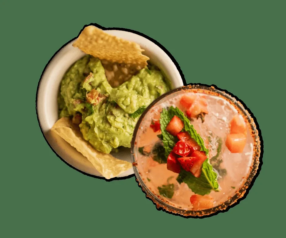 Chunky guacamole with chips and a pink strawberry mint cocktail.