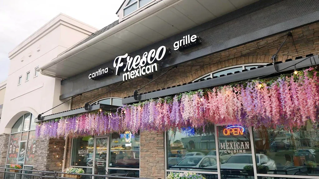 Fresco Mexican Cantina exterior with wisteria, skull art, and "OPEN" sign.