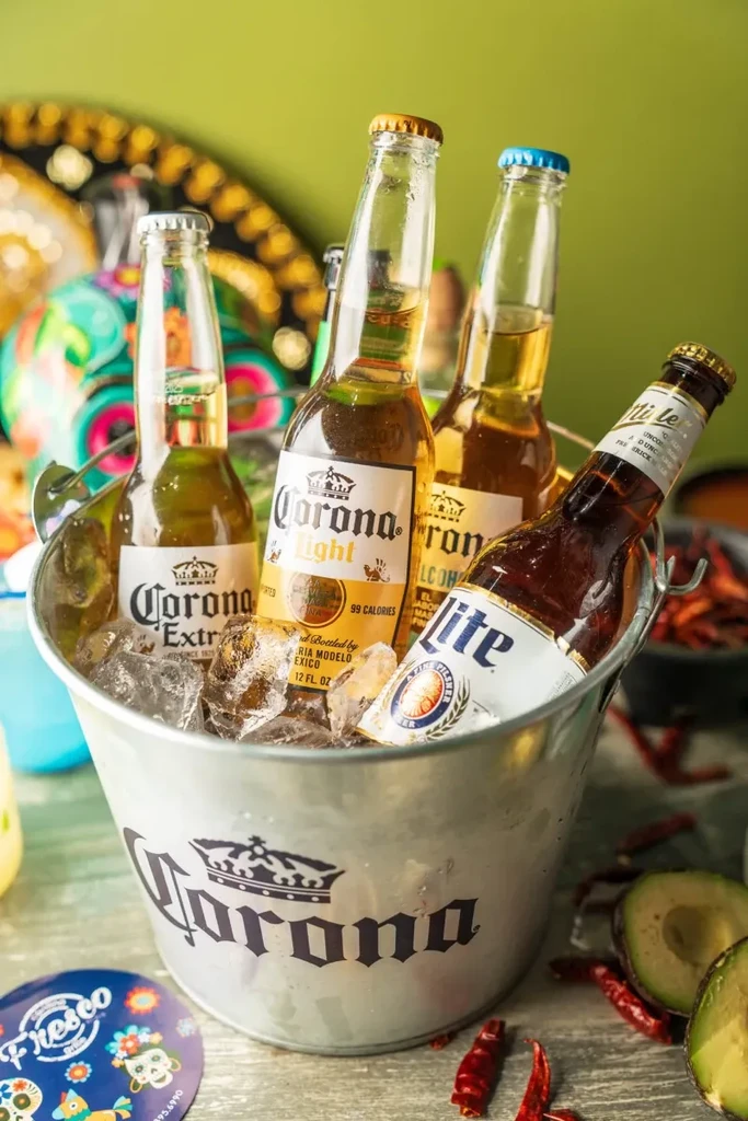 Ice-filled Corona bucket with beers, avocado halves, and chili peppers.