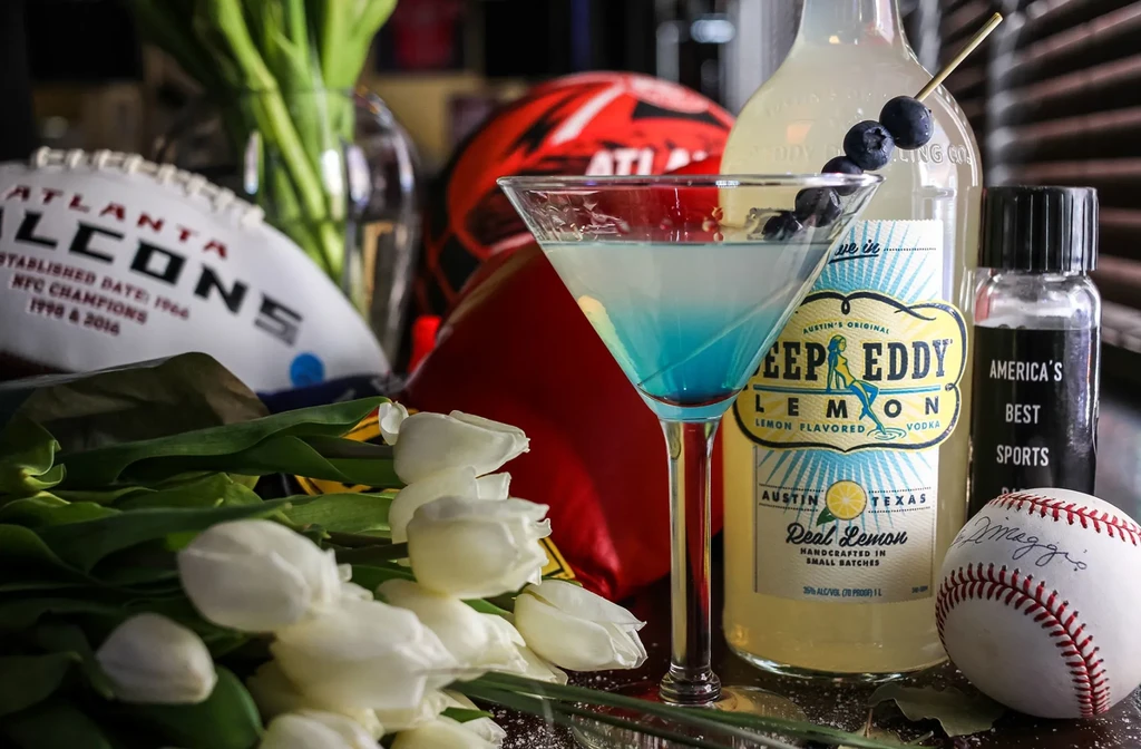 Blue cocktail, Deep Eddy vodka, and Atlanta Falcons sports gear.