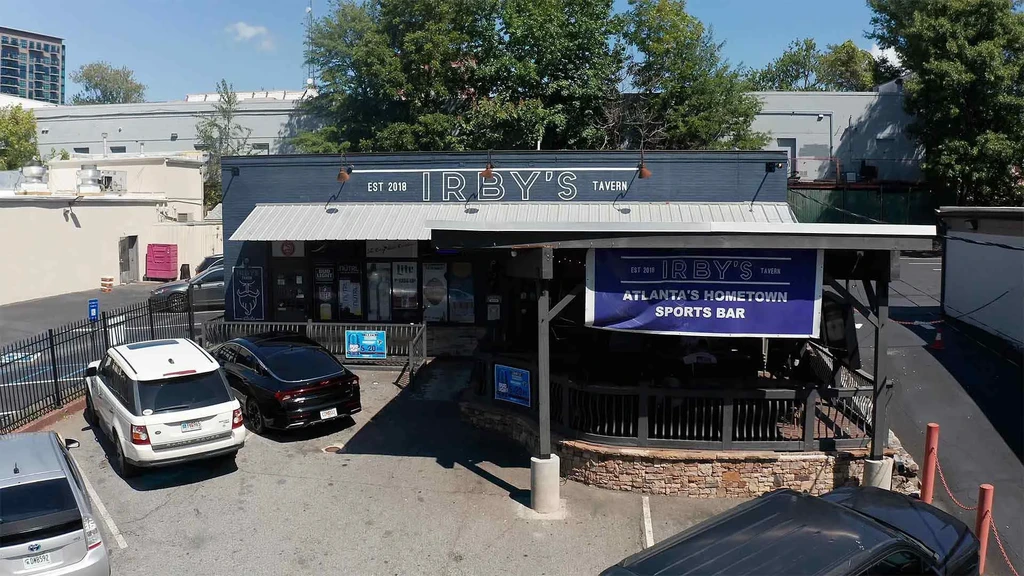 Elevated view of Irby's Tavern, dark building, patio, and cars.