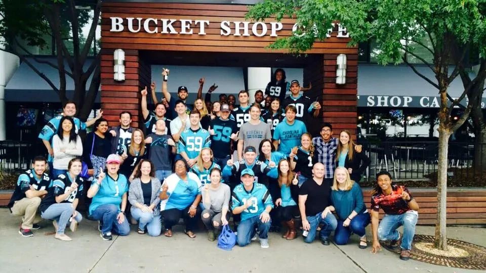 Group of Carolina Panthers fans celebrating outside Bucket Shop Cafe.