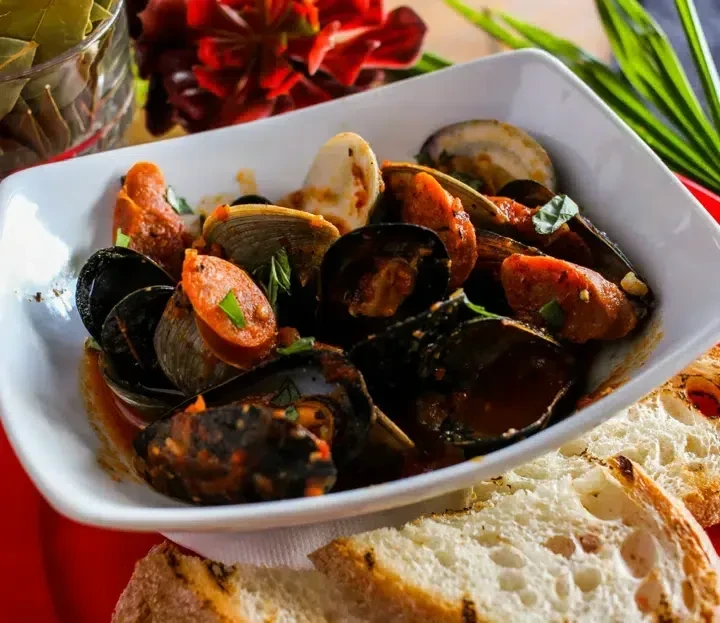 Mussels, clams, and chorizo in a rich sauce, served with crusty bread.