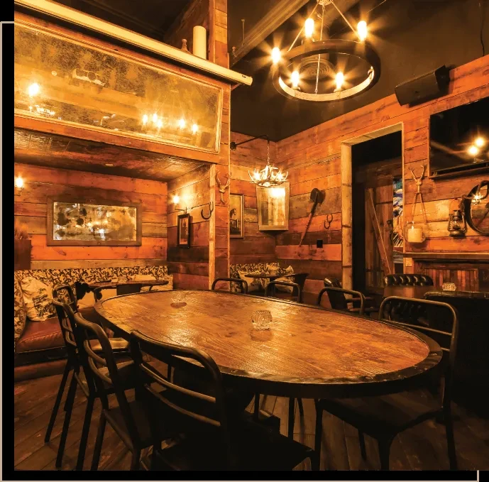 Warm, rustic lodge-style restaurant with wood walls and wagon-wheel chandelier.