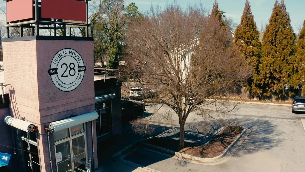 Public House 28, a pinkish-brown brick restaurant, with a bare tree.