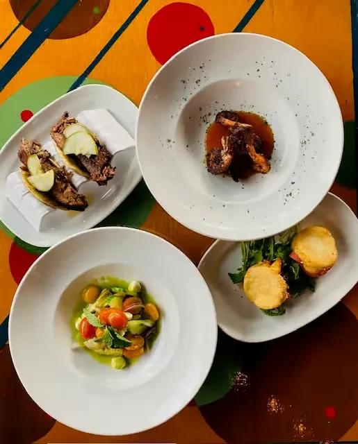 Four distinct dishes artfully arranged on a vibrant, patterned table.