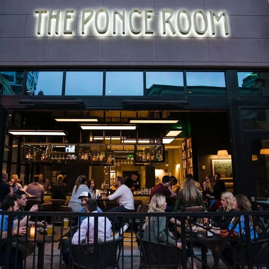 "THE PONCE ROOM" bar at dusk, with busy patio and interior.