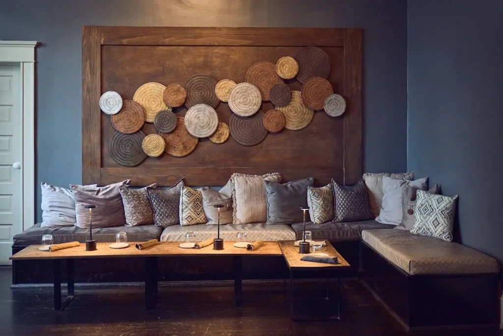 Well-appointed L-shaped banquette with decorative woven plates on a wood panel.