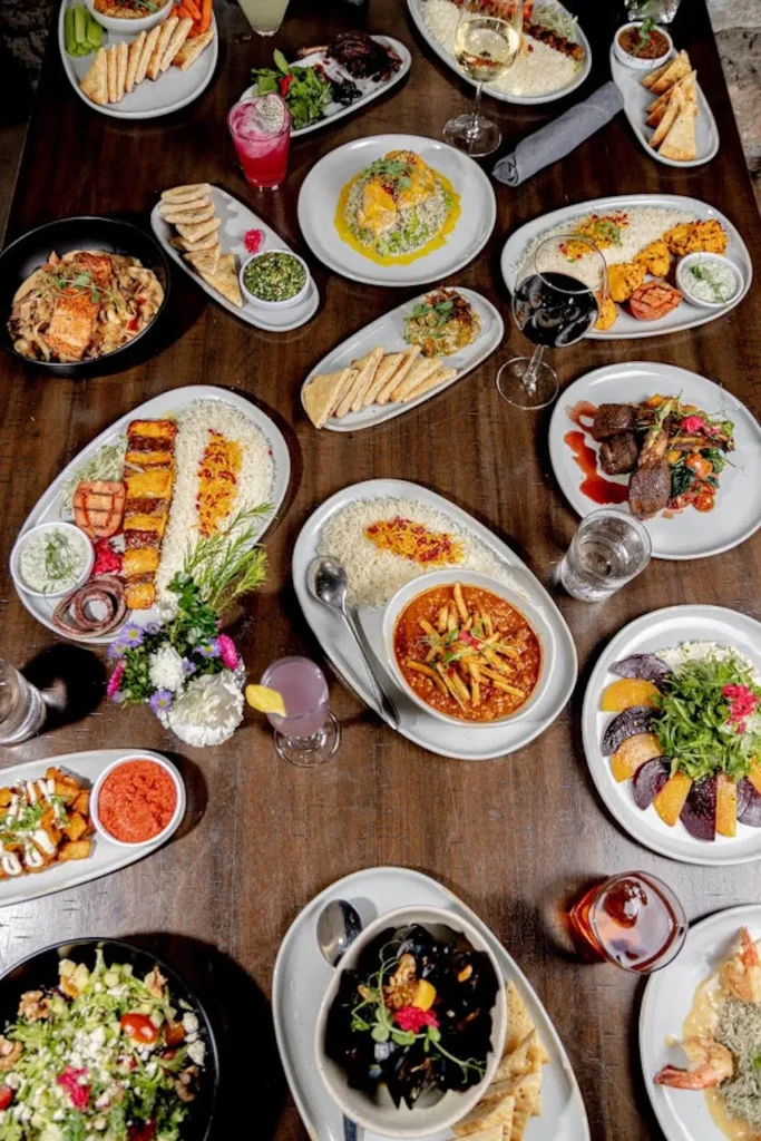 Rustic table laden with diverse culinary creations, drinks, and garnishes.