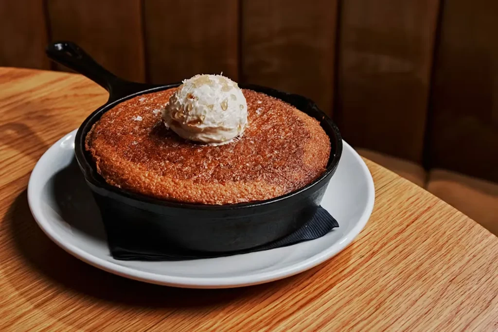 Warm golden-brown cookie in skillet with vanilla ice cream.