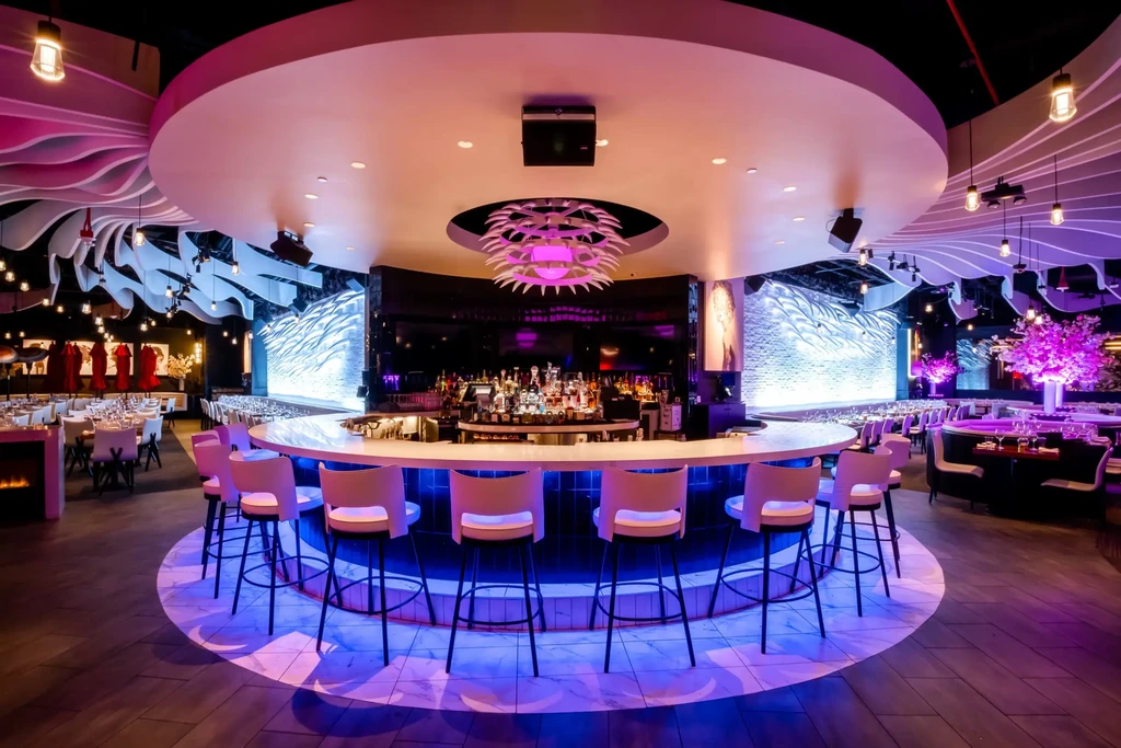 Dramatic blue and purple lit circular bar in a modern restaurant.