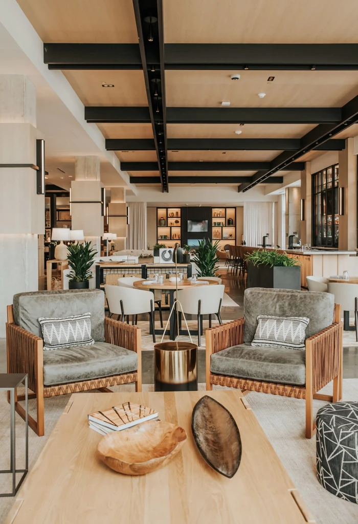Upscale restaurant interior with stylish grey-green armchairs and warm lighting.