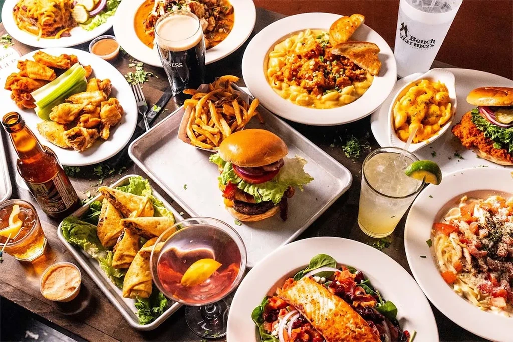 A table full of dishes and drinks at Bench Warmers Sports Grill.