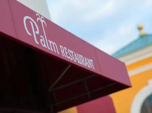 Burgundy awning prominently features 'Palm RESTAURANT' with a palm tree logo.
