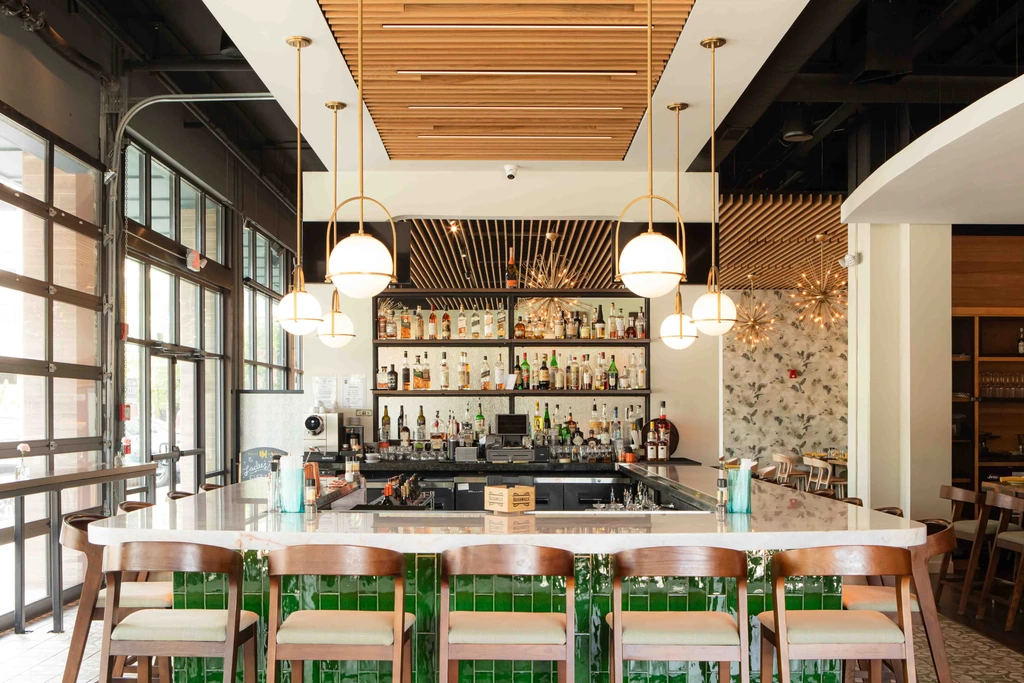 Stylish bar interior featuring a white marble counter and golden pendant lights.