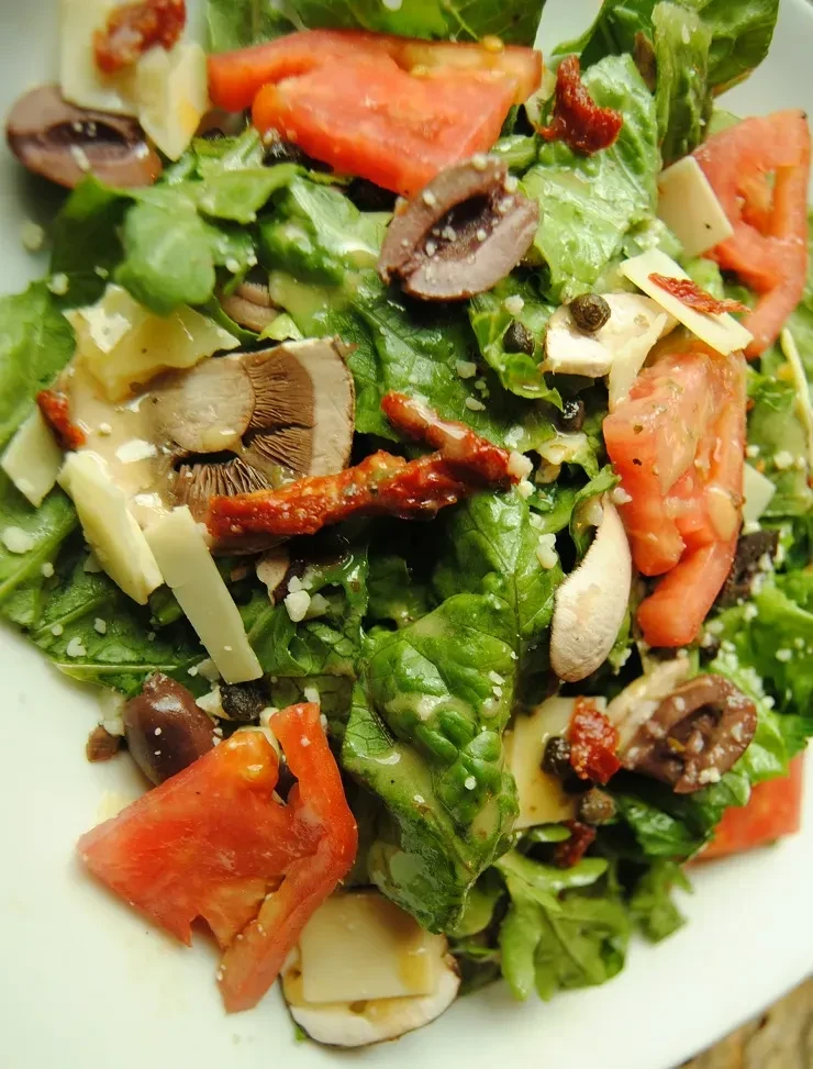 Fresh salad with lettuce, tomatoes, Kalamata olives, mushrooms, Parmesan.