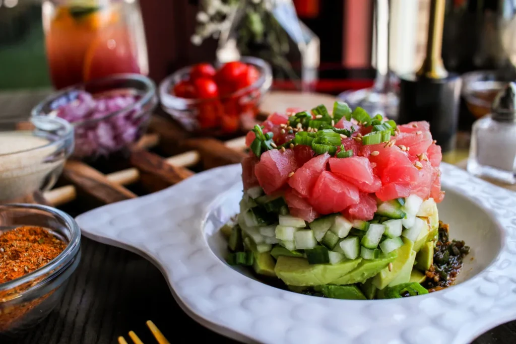 Layered tuna tartare with avocado, cucumber, and green onions.