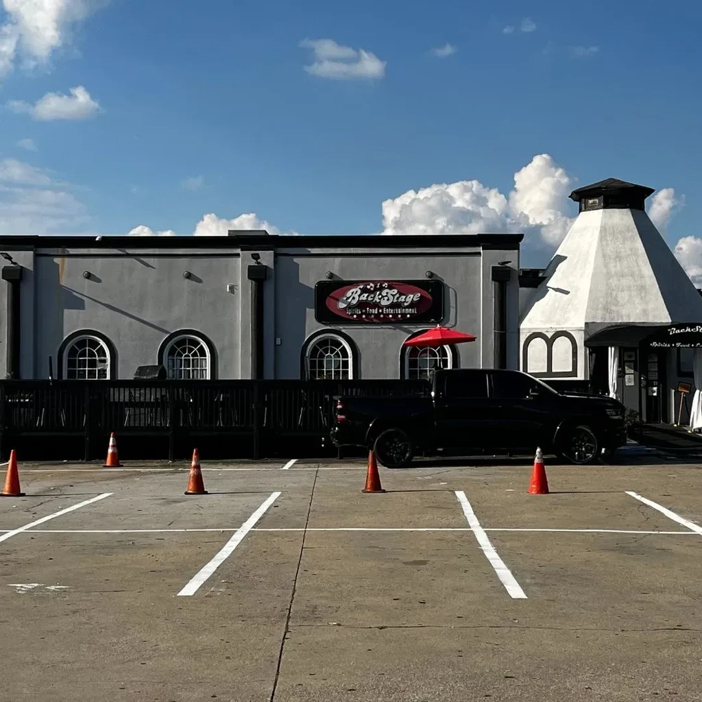 Grey BackStage Spirits building, unique white tower, empty parking lot.