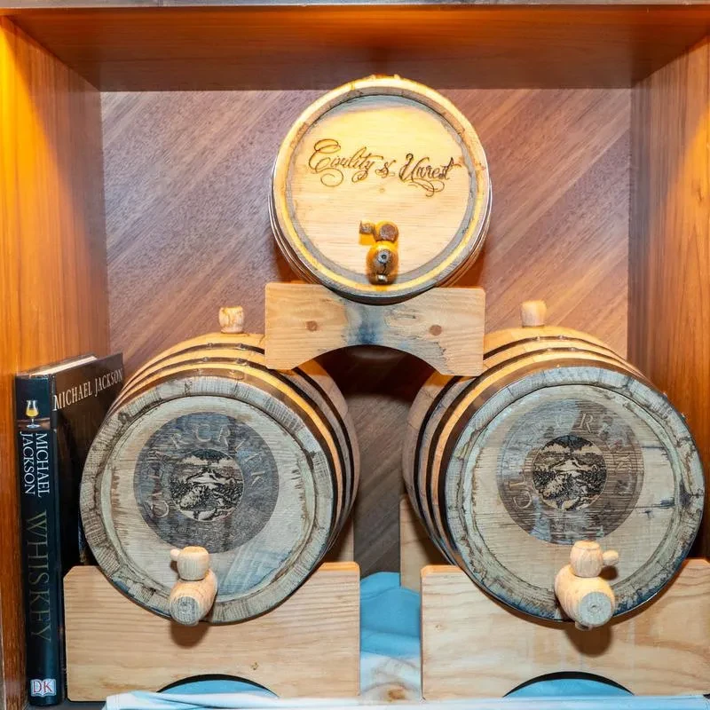 Wooden whiskey barrels stacked with a "Michael Jackson's Whiskey" book.