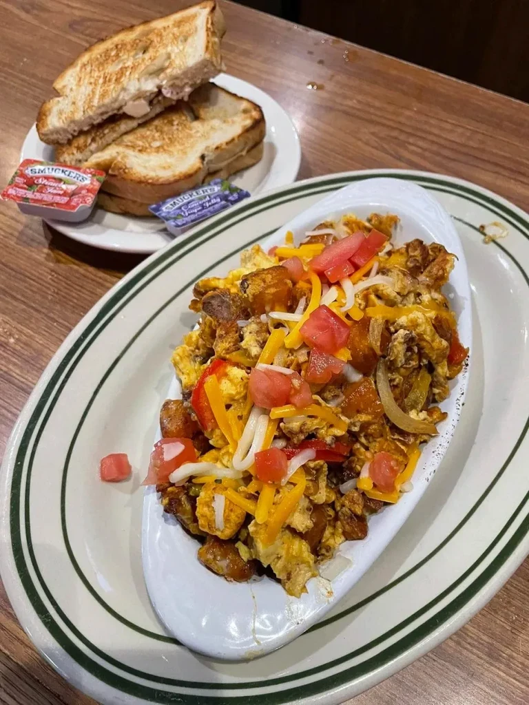 Close-up of a diner-style scrambled egg hash with toast and jam.