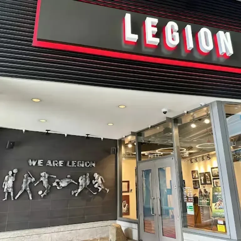 Exterior entrance of "LEGION" building, featuring athlete mural.