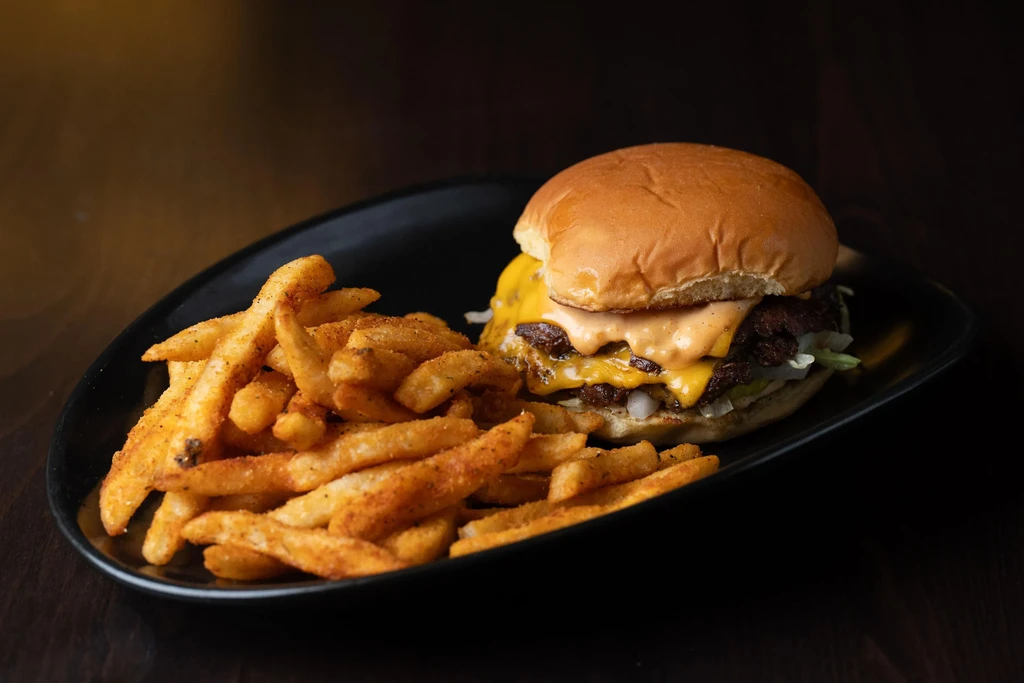 Double cheeseburger with melted cheese and seasoned french fries.