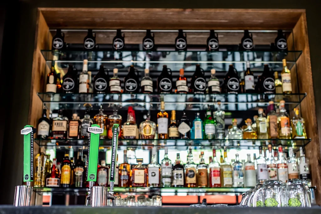 Well-stocked bar with liquor bottles, wine, and Bellevue Brewing beer taps.