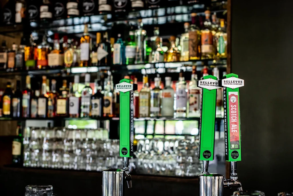 Three green Bellevue Brewing Company beer taps, one for Scotch Ale.