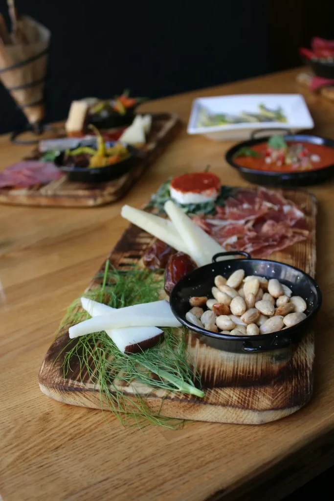 Close-up of charcuterie board with cheeses, cured meats, nuts, and fruit.