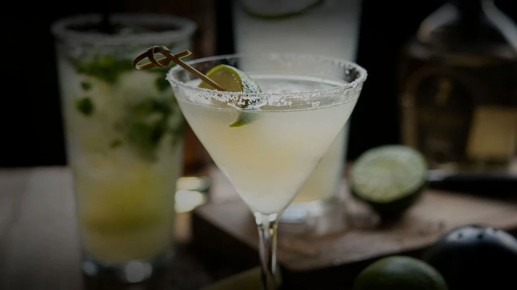 Close-up of a salted rim margarita and other cocktails on a bar.