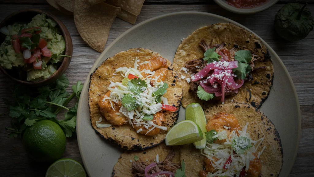 Overhead: Shrimp and meat tacos, guacamole, chips, and salsa.
