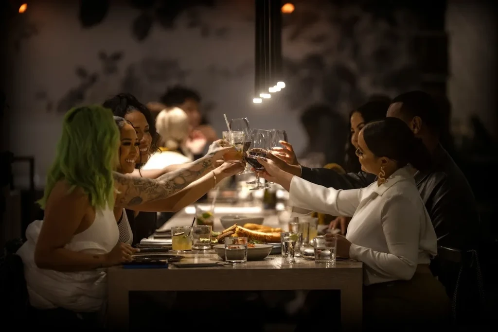 Guests clinking glasses for a celebratory toast in an upscale restaurant.