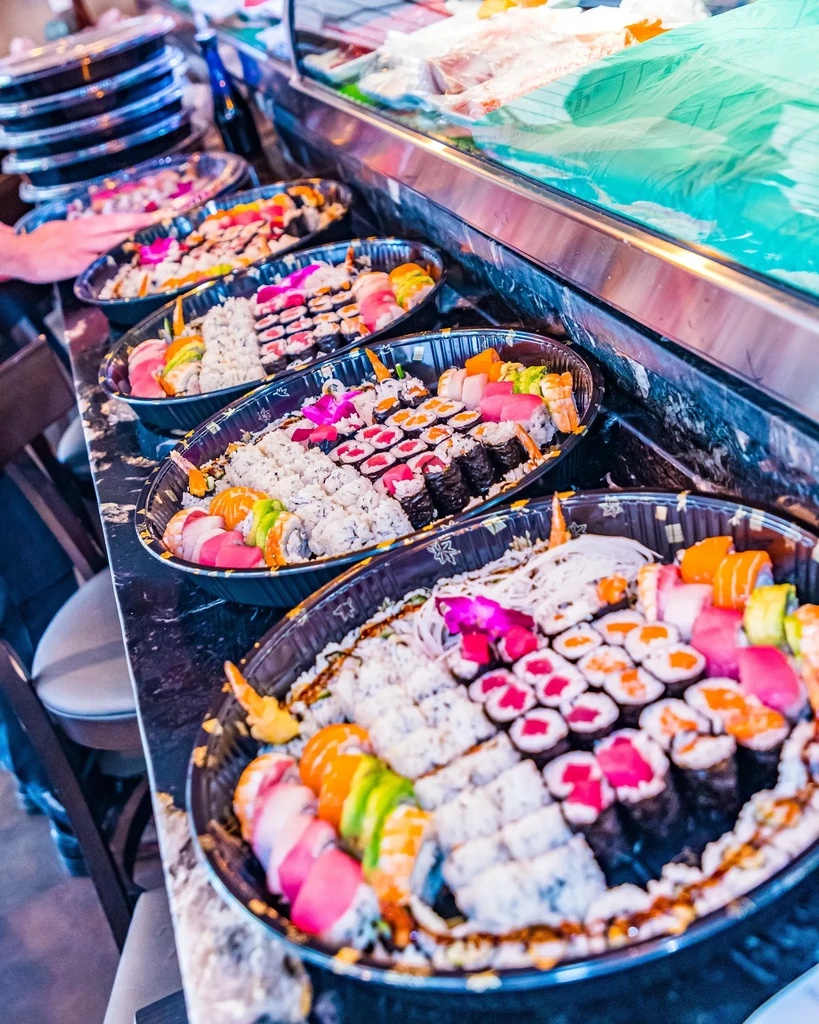 Several vibrant platters of diverse sushi and maki rolls.