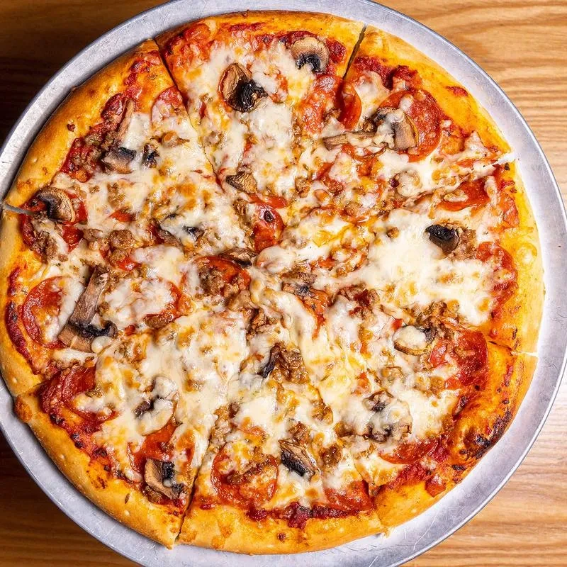 Freshly baked pizza with mozzarella, pepperoni, sausage, and mushrooms.