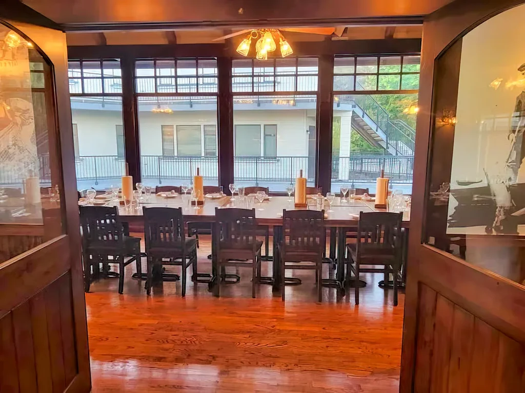 Long wooden dining table set for twelve in a private room.