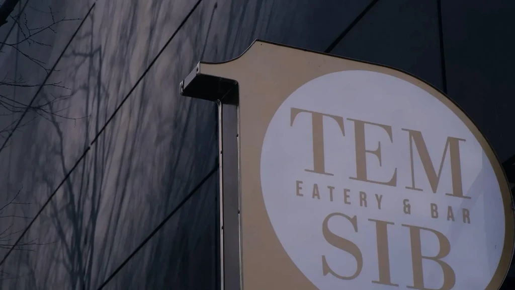 White oval outdoor sign reading TEM EATERY & BAR SIB.