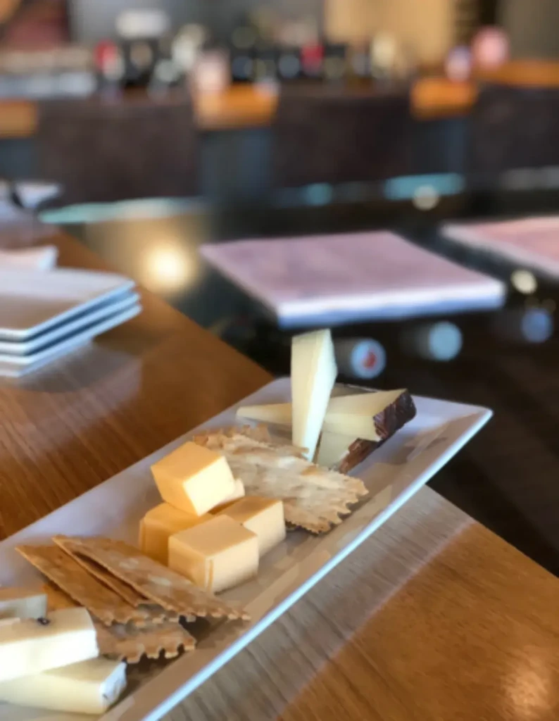 Close-up of a cheese and cracker plate on a wooden table.