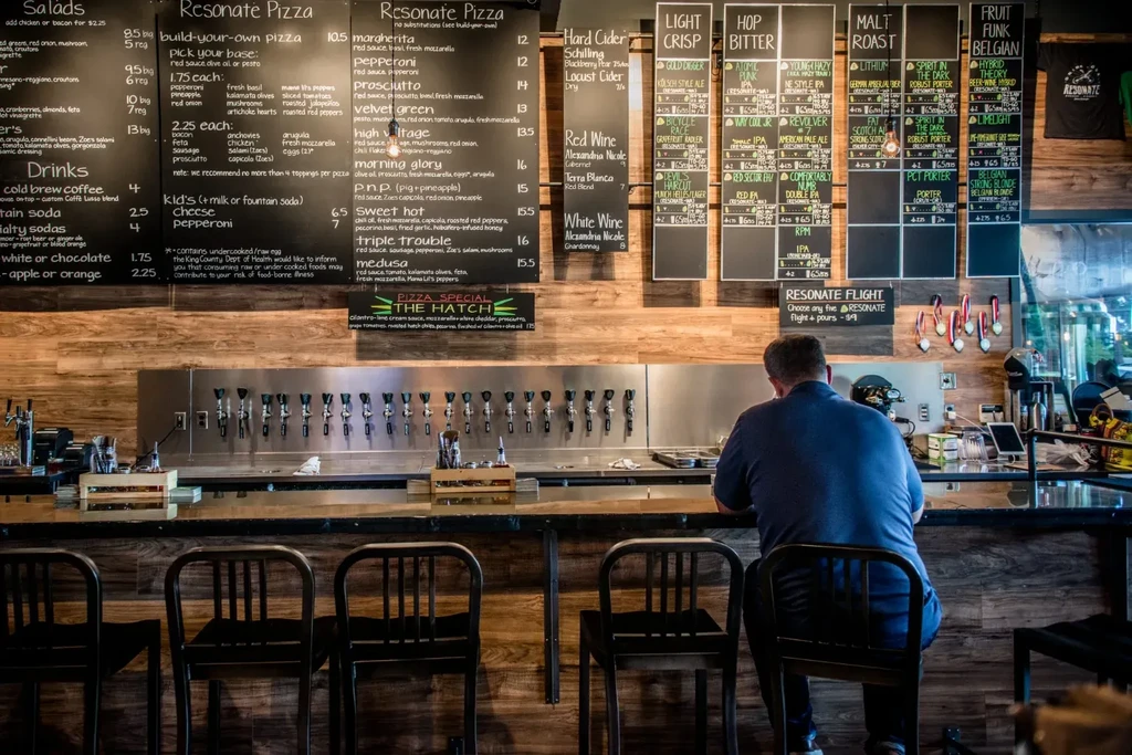 Interior of modern pizzeria bar, extensive menus above many beer taps.