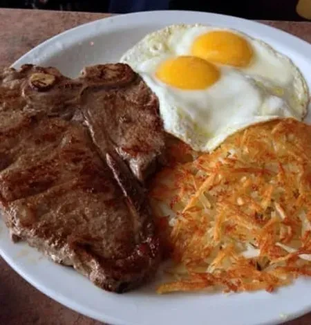Hearty breakfast with steak, fried eggs, and golden hash browns.