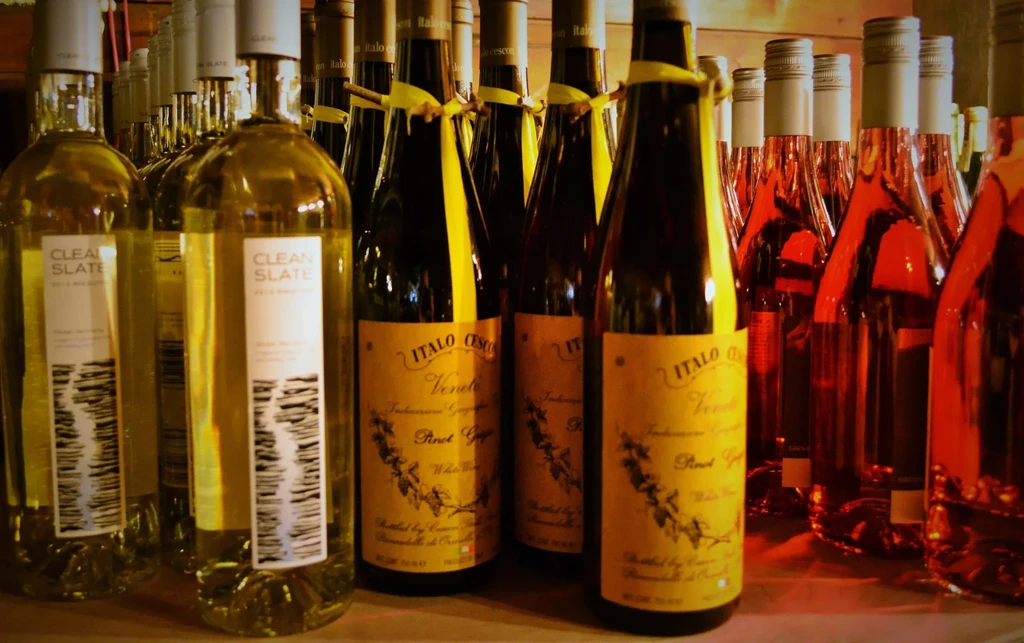 Warmly lit shelves displaying assorted white and red wine bottles.