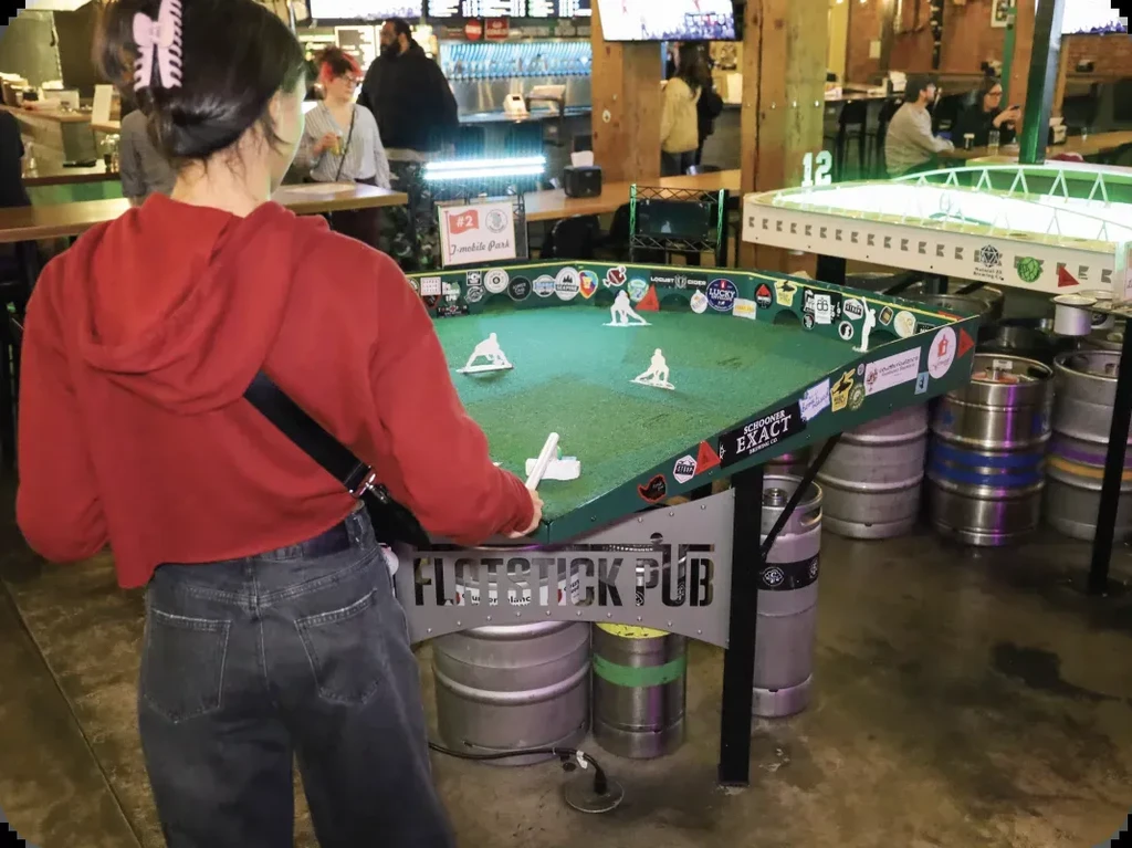 Woman in red plays a table golf game at Flatstick Pub.