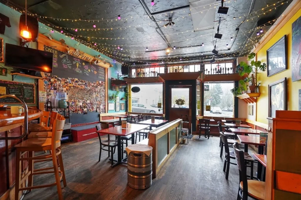 Empty, cozy, eclectic restaurant interior with a bar, blackboard, fairy lights.