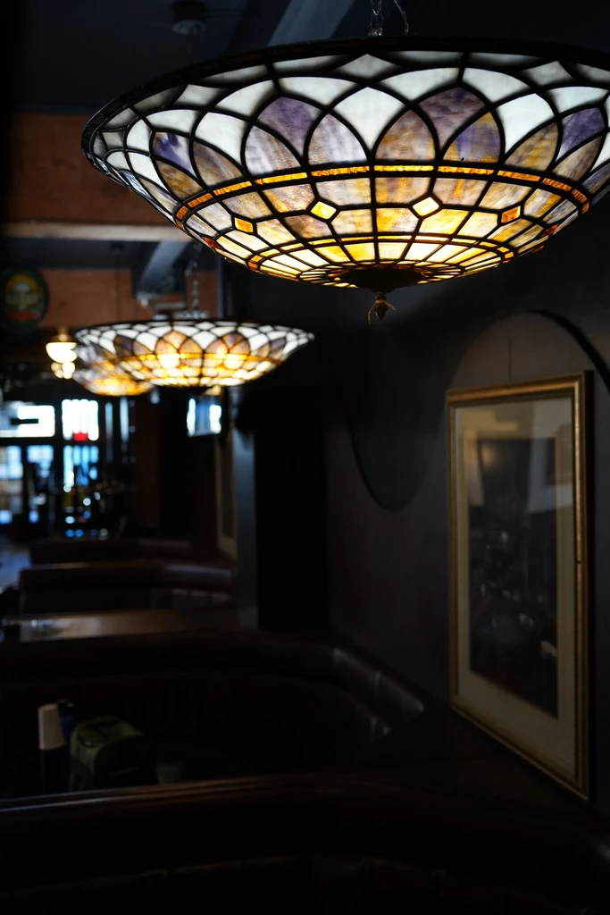 Large, ornate Tiffany-style light with geometric patterns in a restaurant.