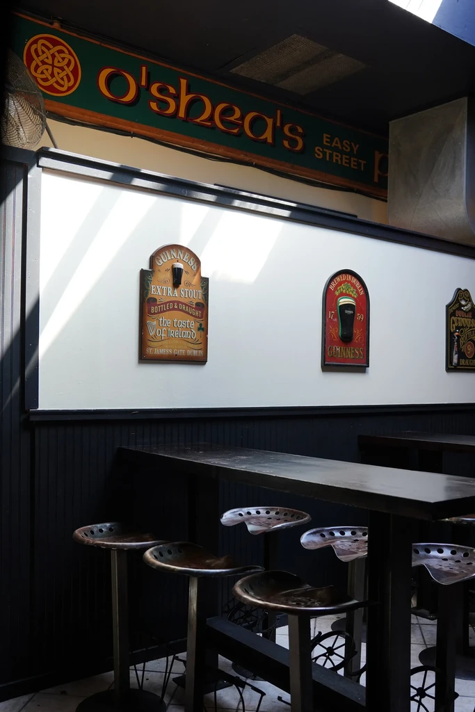 O'shea's Easy Street Pub interior, vintage Guinness signs, industrial bar stools.